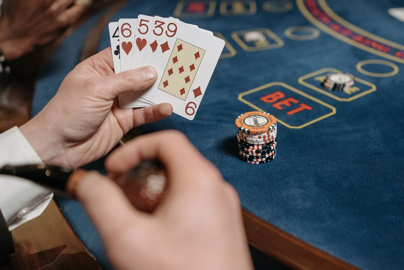 A fan of cards held above a casino table