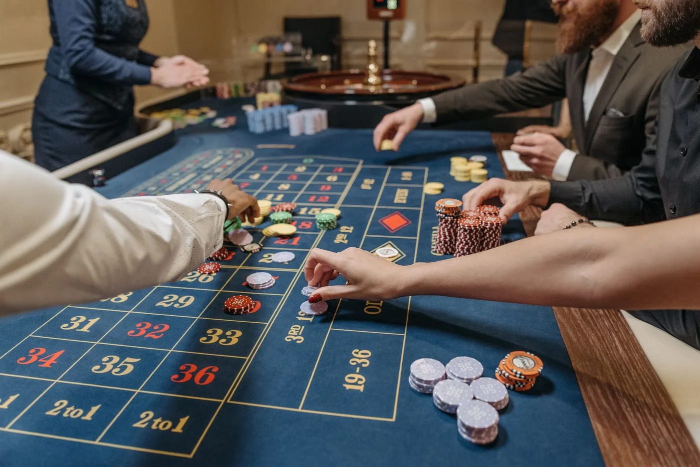 A dealer arranging chips on a roulette layout