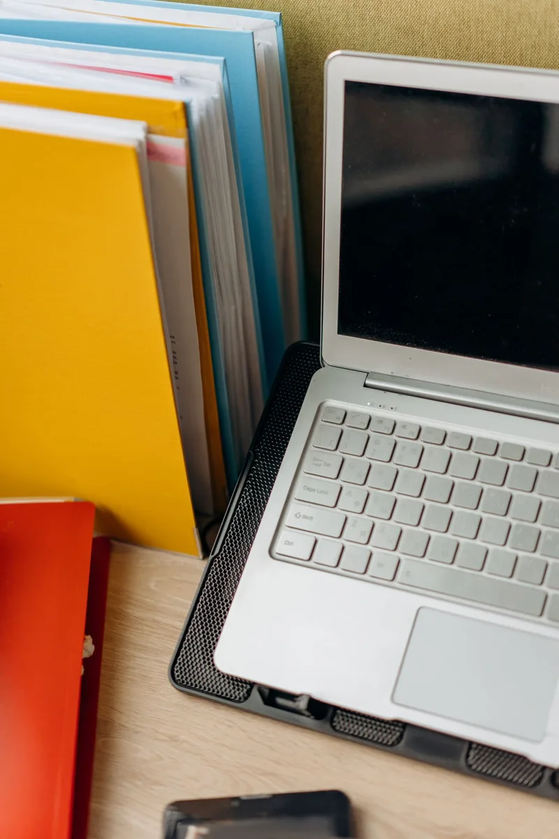 Close view of a laptop keyboard beside a yellow wall